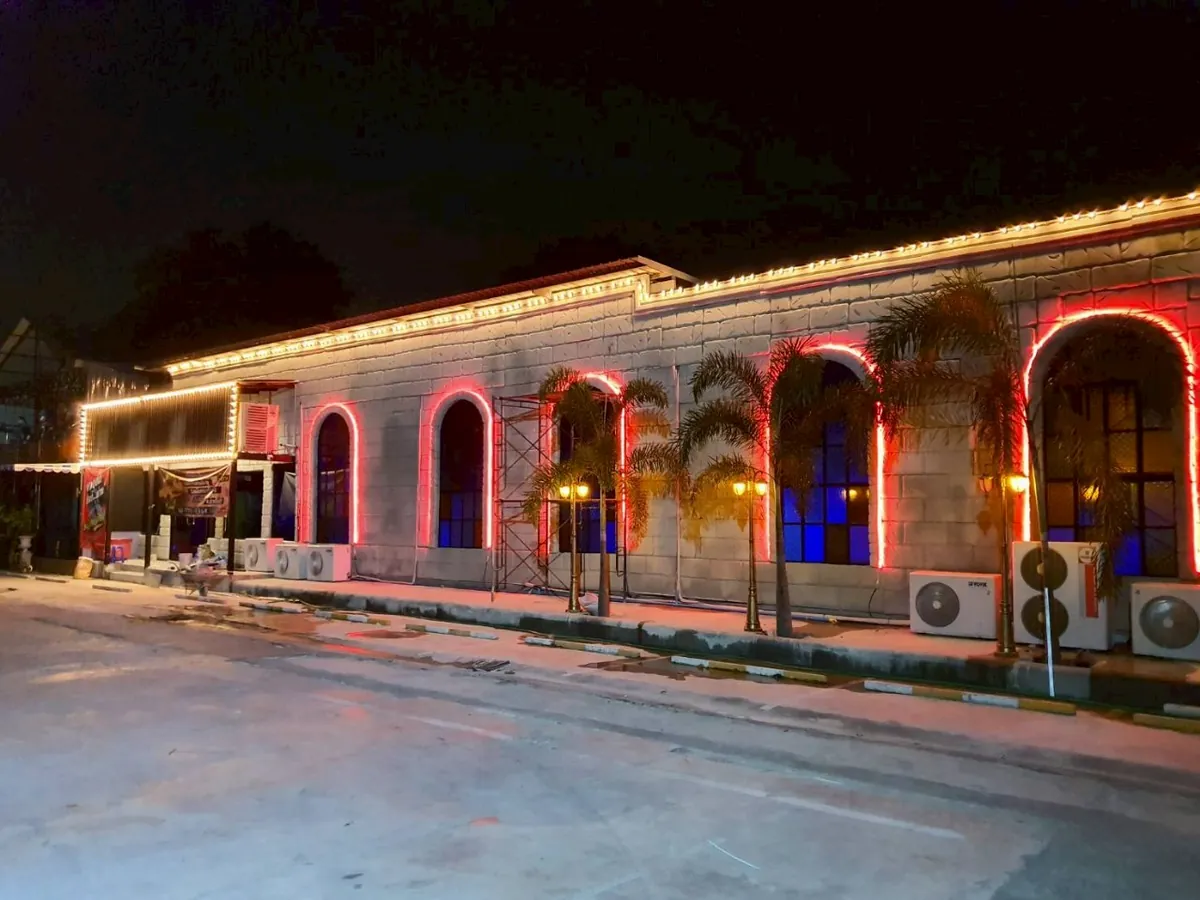 อาคารสถานบันเทิงยามค่ำคืนพร้อมไฟนีออนสีชมพูรอบอาคาร